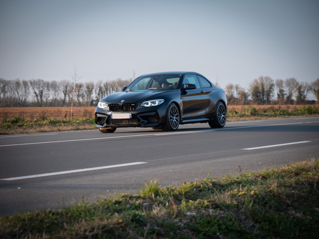 Vue latérale avec jantes sportives – BMW – M2 Compétition – 2019 – Noir Saphirschwarz – 410 ch – 6 Cylindres en Ligne – 16 847 km – Transmission : Sequentielle – Origine France – Privaty Cars – Gestion de vente de voitures de collection et youngtimers en Nouvelle-Aquitaine