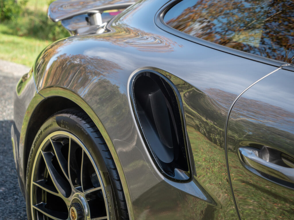 Entrée d'air latérale avec jante noire – PORSCHE – 911 991.2 – 2016 – Gris Quartz – 580 ch – Flat 6 Turbo – 36 900 km – Transmission : Sequentielle – Origine France – Privaty Cars – Vente de voitures de prestige d’occasion dans l’Ouest de la France