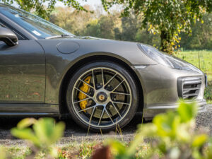 Jante avec étriers de frein jaunes – PORSCHE – 911 991.2 – 2016 – Gris Quartz – 580 ch – Flat 6 Turbo – 36 900 km – Transmission : Sequentielle – Origine France – Privaty Cars – Showroom de voitures de sport haut de gamme dans l’Ouest de la France