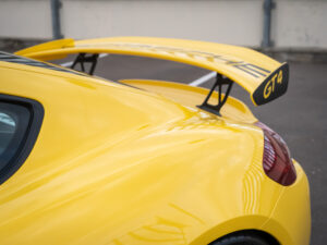 Aileron arrière surélevé – PORSCHE – CAYMAN GT4 – 2016 – Jaune Racing – 385 ch – Flat 6  – 22 900 km – Transmission : Manuelle – Origine Allemagne – Privaty Cars – Spécialiste des supercars d’occasion entre Bordeaux et Nantes