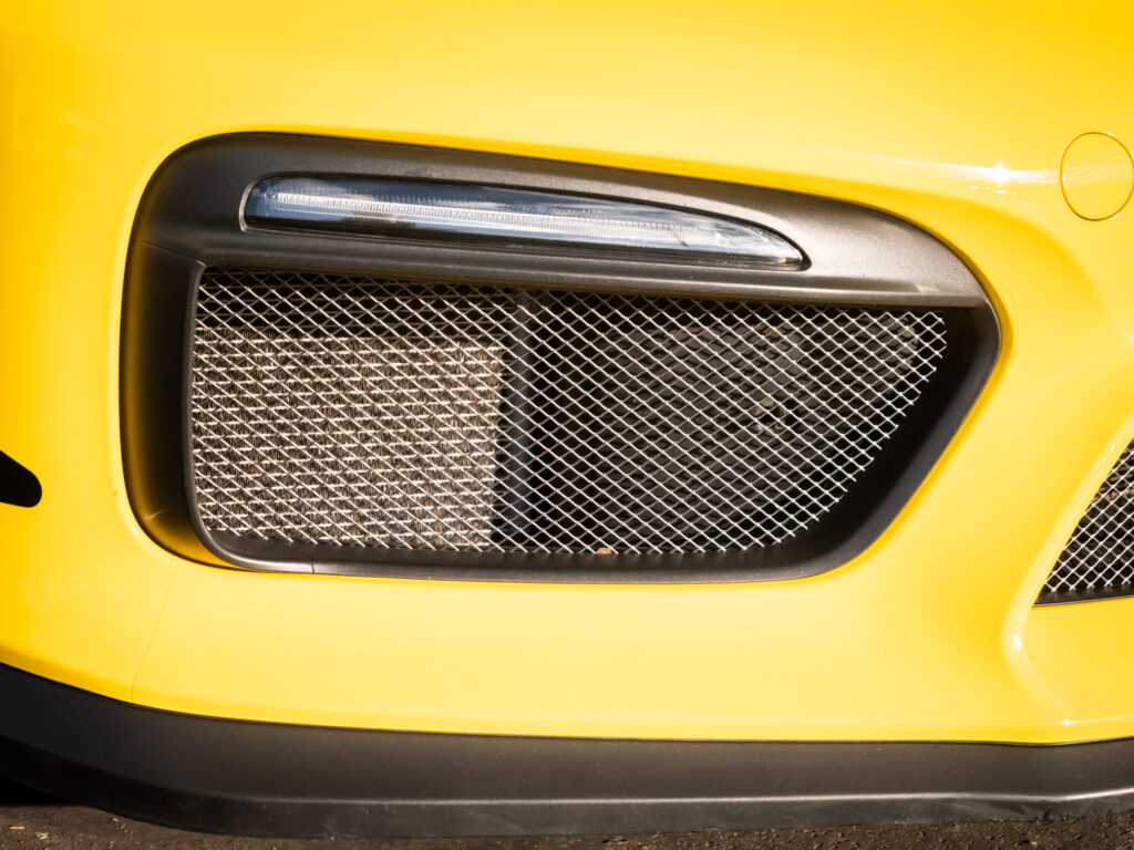 Grille d'aération avec maillage métallique – PORSCHE – CAYMAN GT4 – 2016 – Jaune Racing – 385 ch – Flat 6  – 22 900 km – Transmission : Manuelle – Origine Allemagne – Privaty Cars – Recherche de supercars hors marché à La Rochelle