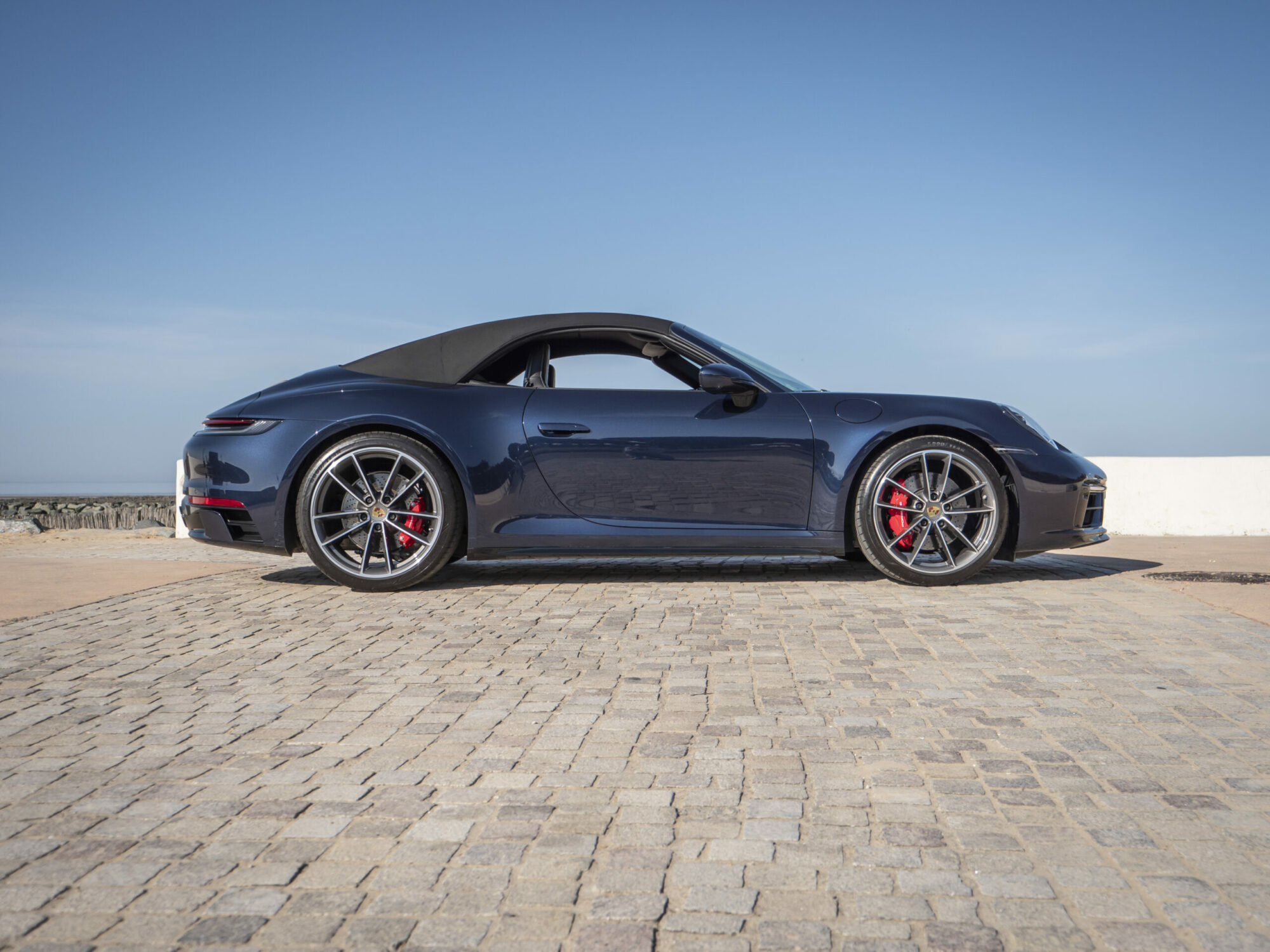 Vue latérale avec toit replié – PORSCHE – 911 992 4S Cabriolet – 2021 – Bleu Nuit Métallisé – 450 ch – Flat 6 Bi-Turbo – 19 900 km – Transmission : Sequentielle – Origine France – Privaty Cars – Vente de voitures de prestige d’occasion près de Niort