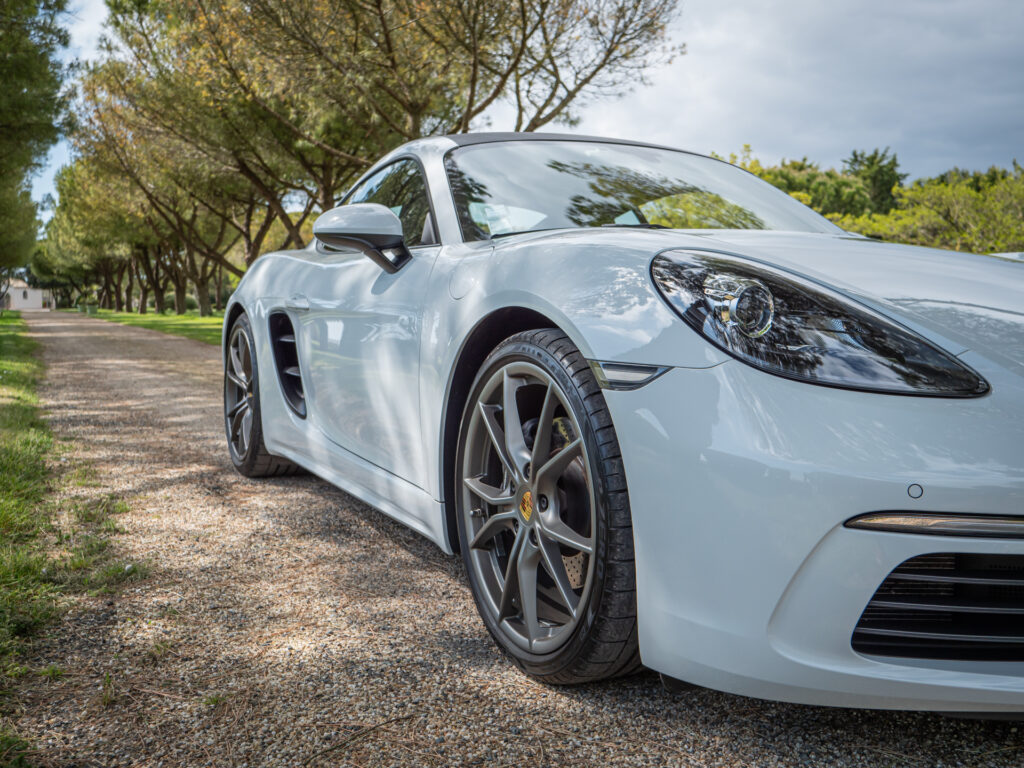 Jante alliage gris foncé – PORSCHE – 718 CAYMAN – 2017 – Blanc Métallisé – 300 ch – Flat 4 Turbo – 28 900 km – Transmission : Sequentielle – Origine France – Privaty Cars – Achat et vente de voitures de luxe d’occasion dans l’Ouest de la France