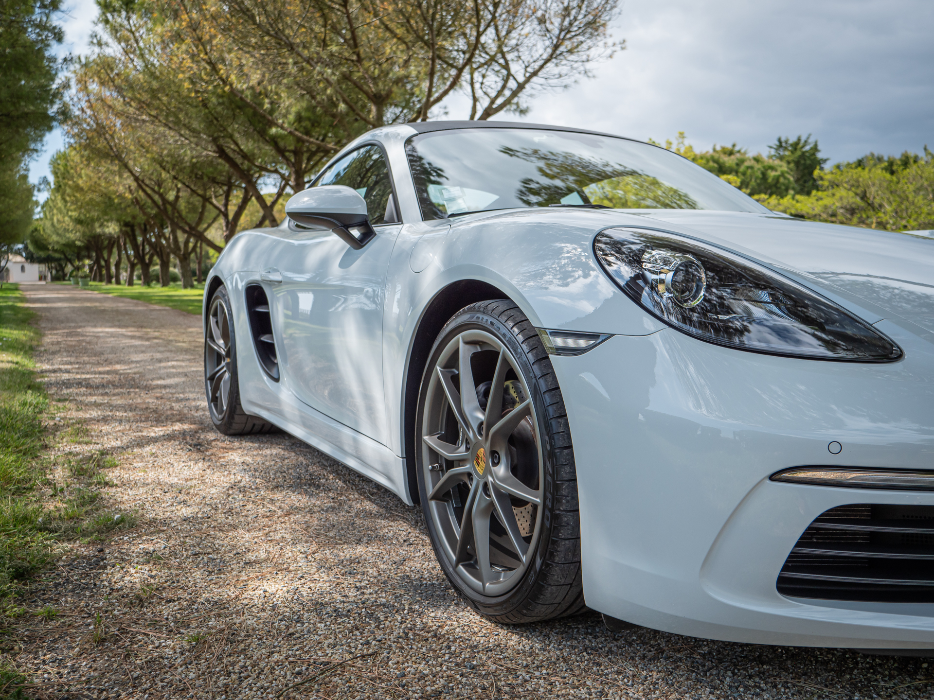 Jante alliage gris foncé – PORSCHE – 718 CAYMAN – 2017 – Blanc Métallisé – 300 ch – Flat 4 Turbo – 28 900 km – Transmission : Sequentielle – Origine France – Privaty Cars – Achat et vente de voitures de luxe d’occasion dans l’Ouest de la France