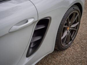 Prise d'air latérale avec grille – PORSCHE – 718 CAYMAN – 2017 – Blanc Métallisé – 300 ch – Flat 4 Turbo – 28 900 km – Transmission : Sequentielle – Origine France – Privaty Cars – Recherche personnalisée de voitures de sport d’occasion en Charente-Maritime