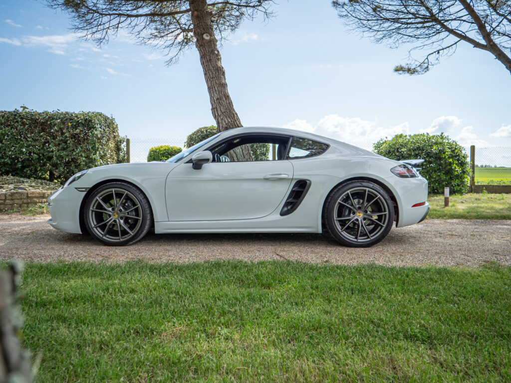 Vue latérale avec jantes sportives – PORSCHE – 718 CAYMAN – 2017 – Blanc Métallisé – 300 ch – Flat 4 Turbo – 28 900 km – Transmission : Sequentielle – Origine France – Privaty Cars – Vente de véhicules d’investissement et de collection proche de Bordeaux