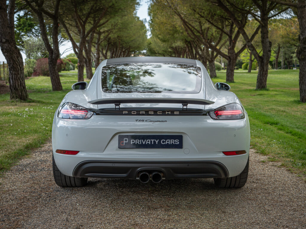 Vue arrière avec aileron intégré – PORSCHE – 718 CAYMAN – 2017 – Blanc Métallisé – 300 ch – Flat 4 Turbo – 28 900 km – Transmission : Sequentielle – Origine France – Privaty Cars – Conciergerie automobile pour véhicules de sport en Nouvelle-Aquitaine