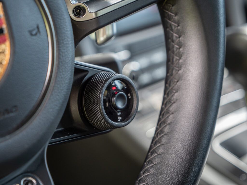 Commandes au volant avec molette – PORSCHE – 718 CAYMAN – 2017 – Blanc Métallisé – 300 ch – Flat 4 Turbo – 28 900 km – Transmission : Sequentielle – Origine France – Privaty Cars – Vente de voitures de sport d’occasion à La Rochelle