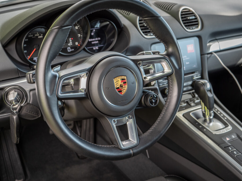 Volant – PORSCHE – 718 CAYMAN – 2017 – Blanc Métallisé – 300 ch – Flat 4 Turbo – 28 900 km – Transmission : Sequentielle – Origine France – Privaty Cars – Achat et vente de voitures de sport d’occasion entre Bordeaux et Nantes