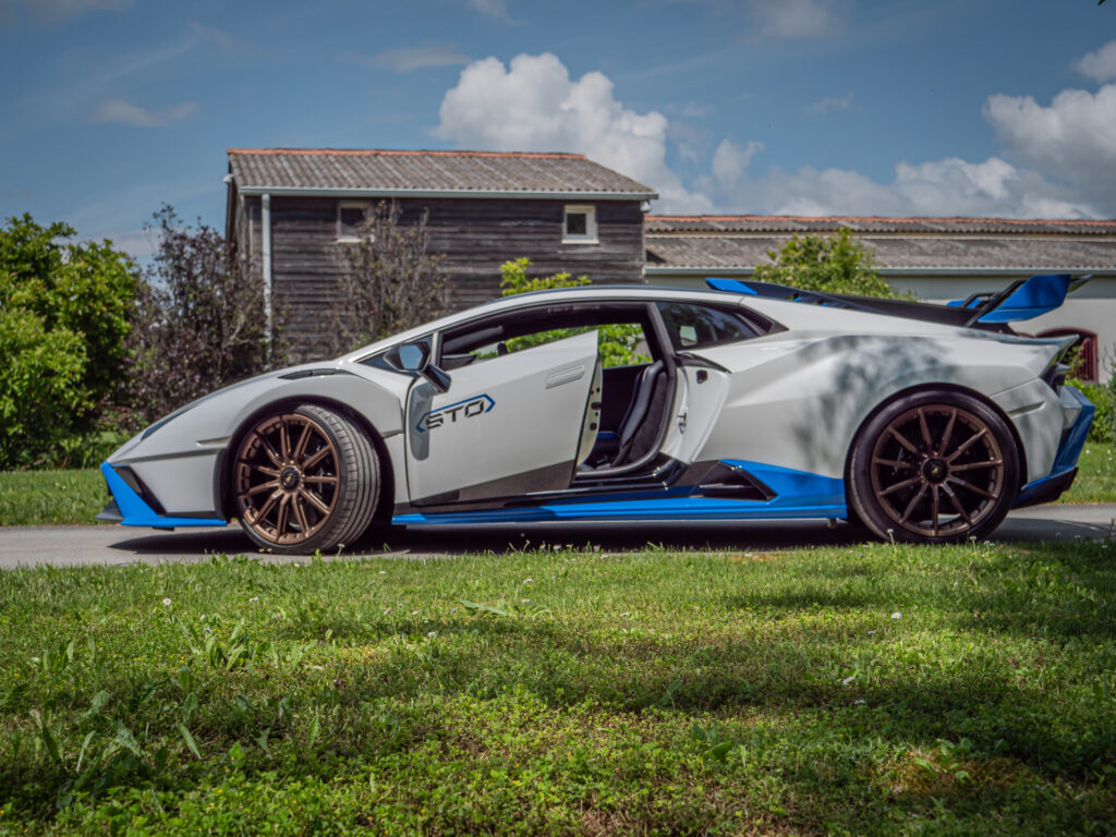 Vue latérale avec portes ouvertes – LAMBORGHINI – HURACAN STO – 2021 – Bianco Asopo – 640 ch – V10 Atmo – 13 900 km – Transmission : Sequentielle – Origine Italie – Privaty Cars – Recherche de supercars hors marché en Charente-Maritime