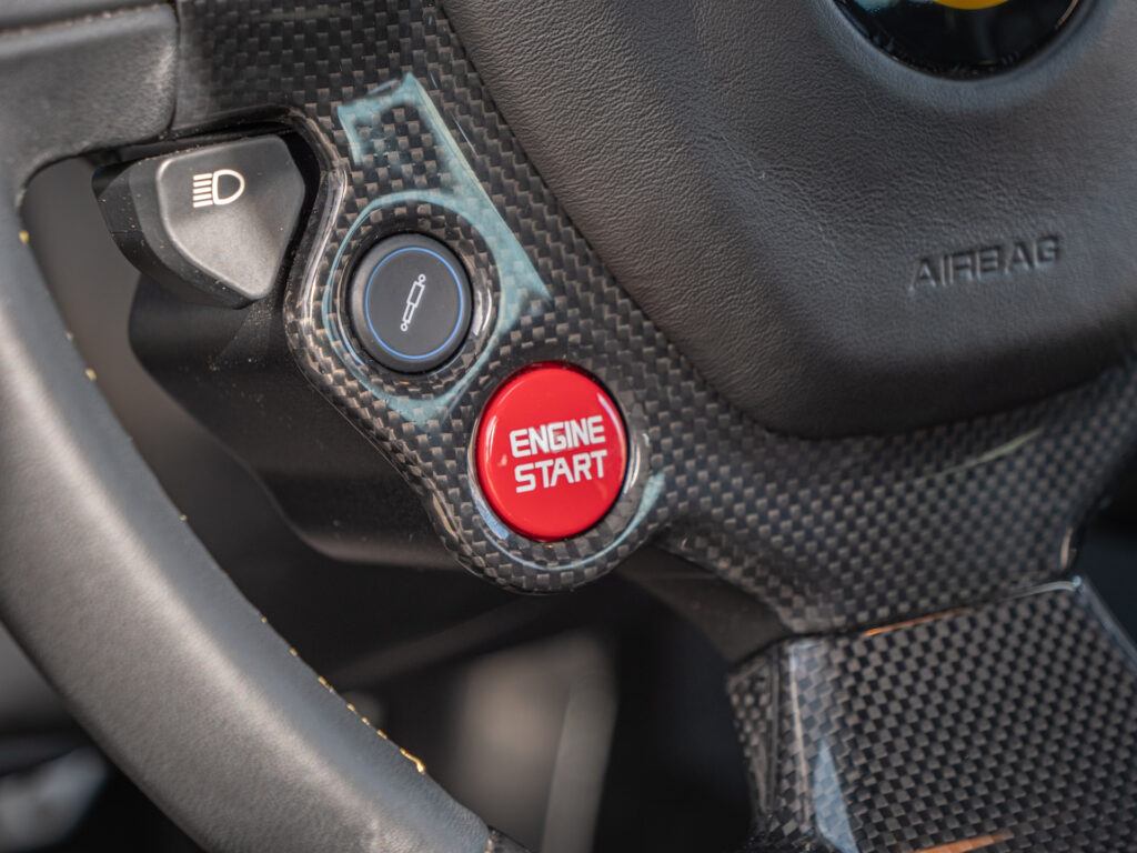 Bouton de démarrage moteur rouge – FERRARI – 458 Italia – 2012 – Nero – 570 ch – V8 Atmosphérique – 34 900 km – Transmission : Sequentielle – Origine Allemagne – Privaty Cars – Vente de voitures de prestige d’occasion à 2 heures de Paris en TGV