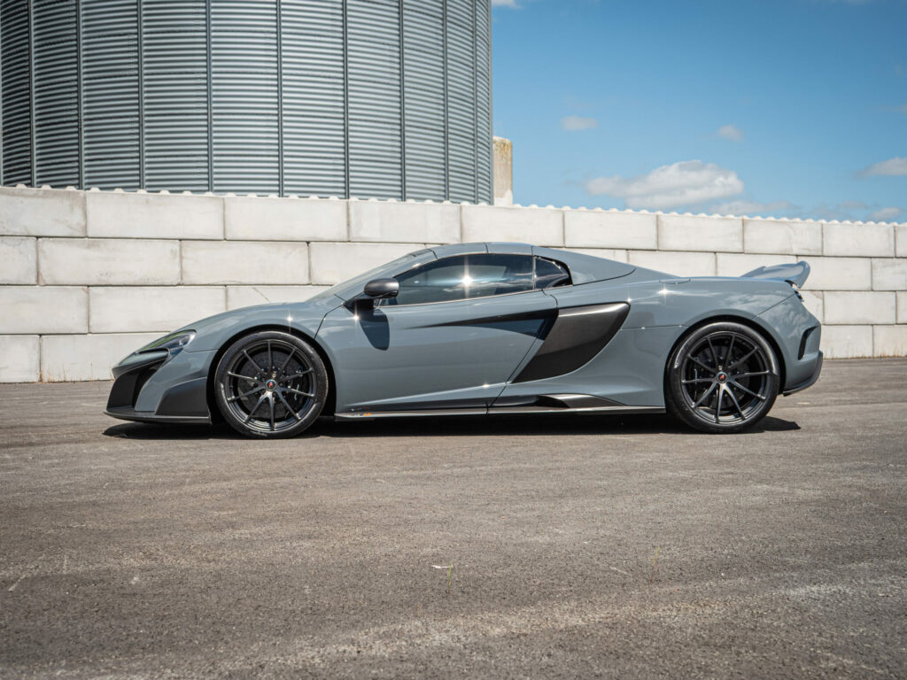 Vue latérale avec jantes noires – MCLAREN – 675LT Spider – 2017 – Chicane Grey – 675 ch – V8 Bi-Turbo – 11 900 km – Transmission : Sequentielle – Origine Angleterre – Privaty Cars – Dépôt-vente de voitures de sport et véhicules d’exception près de Niort