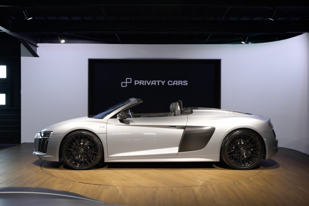 Vue latérale avec jantes noires – AUDI – R8 Spyder – 2017 – Argent Métallisé – 26 900 km – 540 ch – V10 Atmo – Transmission : Sequentielle – Origine France – Privaty Cars – Spécialiste des voitures de sport d’occasion proche de Bordeaux