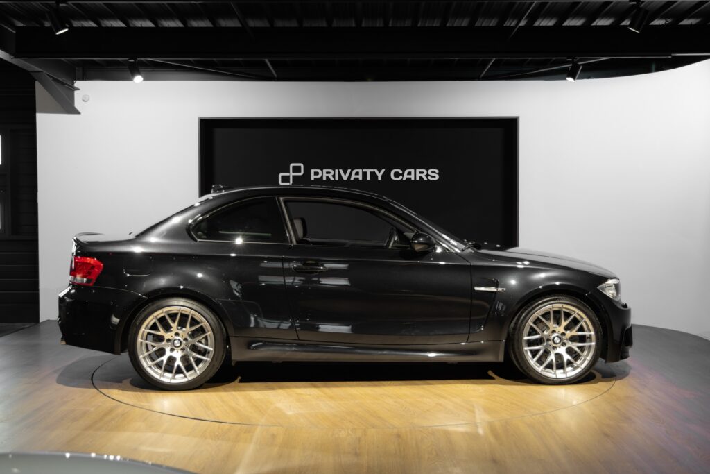 Vue latérale avec jantes en alliage – BMW – 1M – 2012 – Noir Saphirschwarz Metallic – 47 900 km – 340 ch – 6 cylindres en ligne bi-turbo – Transmission : Manuelle – Origine France – Privaty Cars – Chasseur de voitures de sport sur mesure près de Poitiers