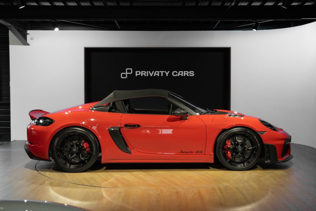 Vue latérale avec toit replié – PORSCHE – 718 Spyder RS – 2024 – Rouge Indien – 1 900 km – 500 ch – Flat 6 Atmo – Transmission : Sequentielle – Origine France – Privaty Cars – Dépôt-vente de véhicules PORSCHE en Charente-Maritime