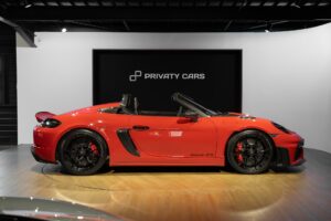 Vue latérale avec jantes noires – PORSCHE – 718 Spyder RS – 2024 – Rouge Indien – 1 900 km – 500 ch – Flat 6 Atmo – Transmission : Sequentielle – Origine France – Privaty Cars – Reprise de voitures de sport et collection proche de Nantes