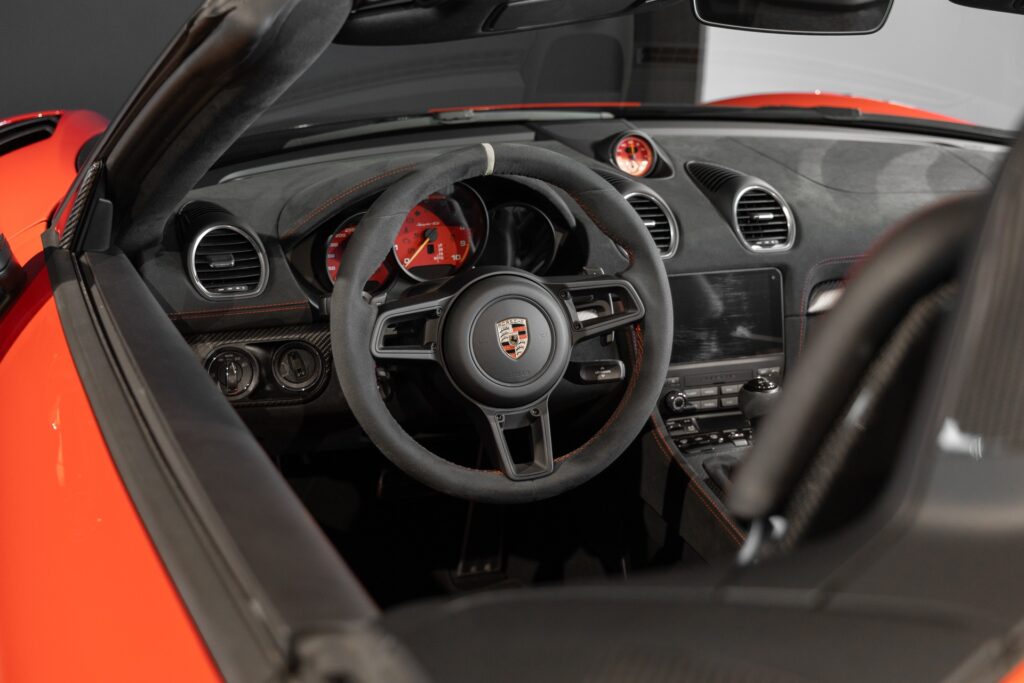 Volant – PORSCHE – 718 Spyder RS – 2024 – Rouge Indien – 1 900 km – 500 ch – Flat 6 Atmo – Transmission : Sequentielle – Origine France – Privaty Cars – Spécialiste des voitures de sport d’occasion dans l’Ouest de la France