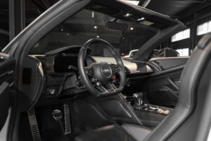 Volant sport en cuir perforé – AUDI – R8 Spyder V10 Plus – 2017 – Blanc Ibis – 34 900 km – 610 ch – V10 Atmo – Transmission : Sequentielle – Origine France – Privaty Cars – Dépôt-vente de voitures de sport et véhicules d’exception proche de Nantes