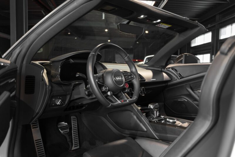 Volant sport en cuir perforé – AUDI – R8 Spyder V10 Plus – 2017 – Blanc Ibis – 34 900 km – 610 ch – V10 Atmo – Transmission : Sequentielle – Origine France – Privaty Cars – Dépôt-vente de voitures de sport et véhicules d’exception proche de Nantes