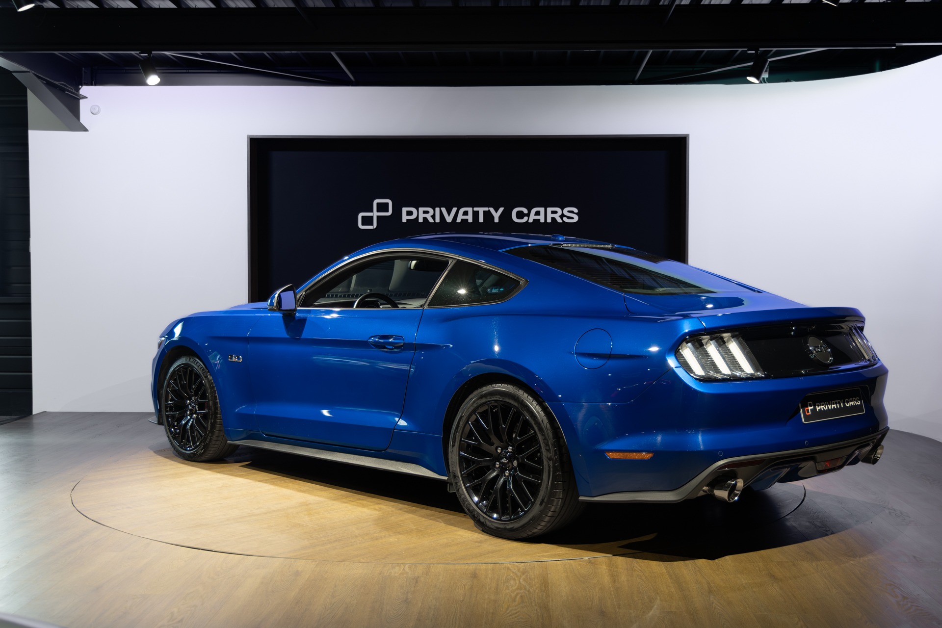 Vue arrière avec jantes noires – FORD – Mustang Fastback – 2018 – Bleu Lightning – 37 900 km – 421 ch – V8 atmo – Transmission : Séquentielle – Origine France – Privaty Cars – Vente de voitures de prestige d’occasion en Charente-Maritime