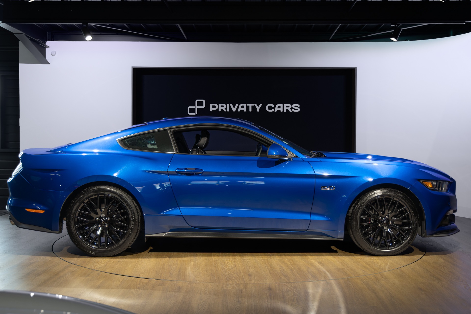 Vue latérale avec jantes noires – FORD – Mustang Fastback – 2018 – Bleu Lightning – 37 900 km – 421 ch – V8 atmo – Transmission : Séquentielle – Origine France – Privaty Cars – Showroom de voitures de sport haut de gamme en Nouvelle-Aquitaine