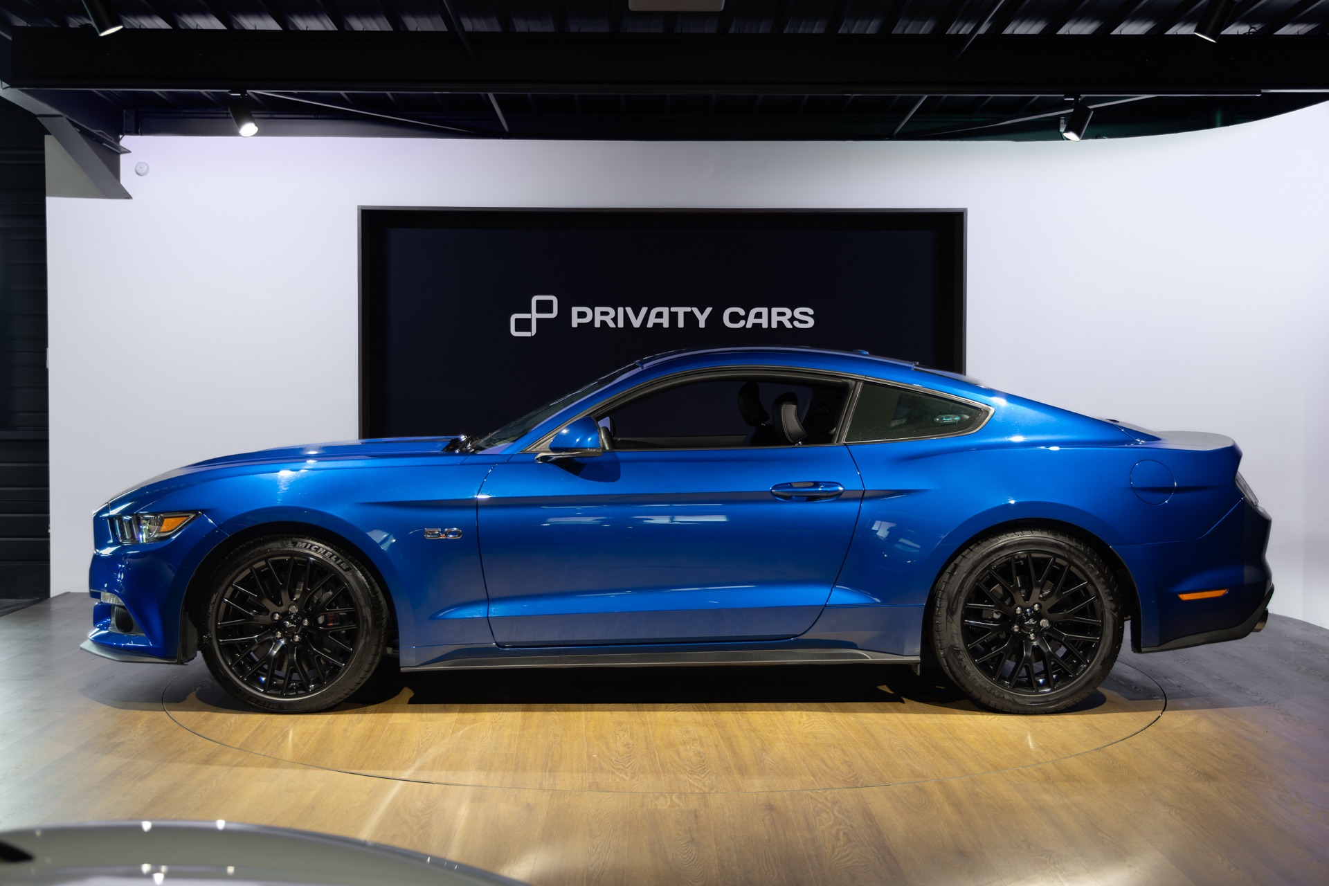 Vue latérale avec jantes noires – FORD – Mustang Fastback – 2018 – Bleu Lightning – 37 900 km – 421 ch – V8 atmo – Transmission : Séquentielle – Origine France – Privaty Cars – Courtage automobile pour véhicules exclusifs à La Rochelle