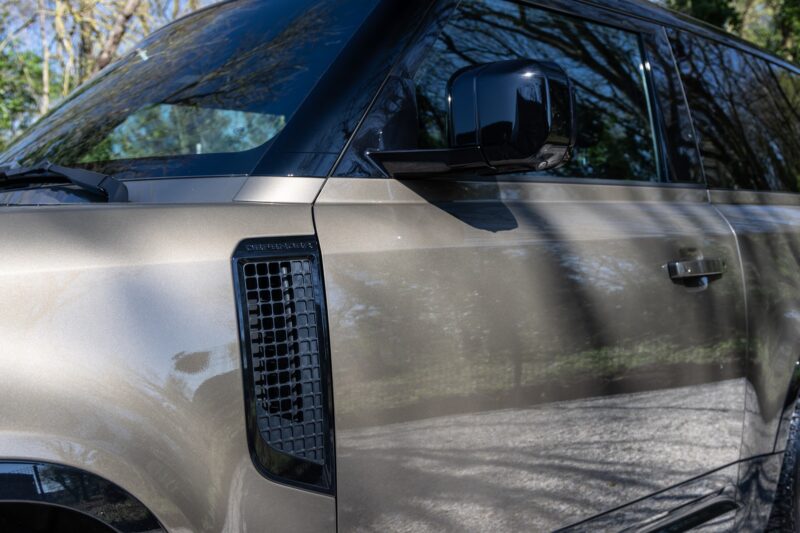Grille d'aération latérale noire – LAND ROVER – Defender 90 – 2023 – Gondwana Stone Brillant – 33 000 km – 400 ch – 6 cylindres en ligne – Transmission : Automatique – Origine France – Privaty Cars – Showroom de voitures de sport haut de gamme près de Poitiers