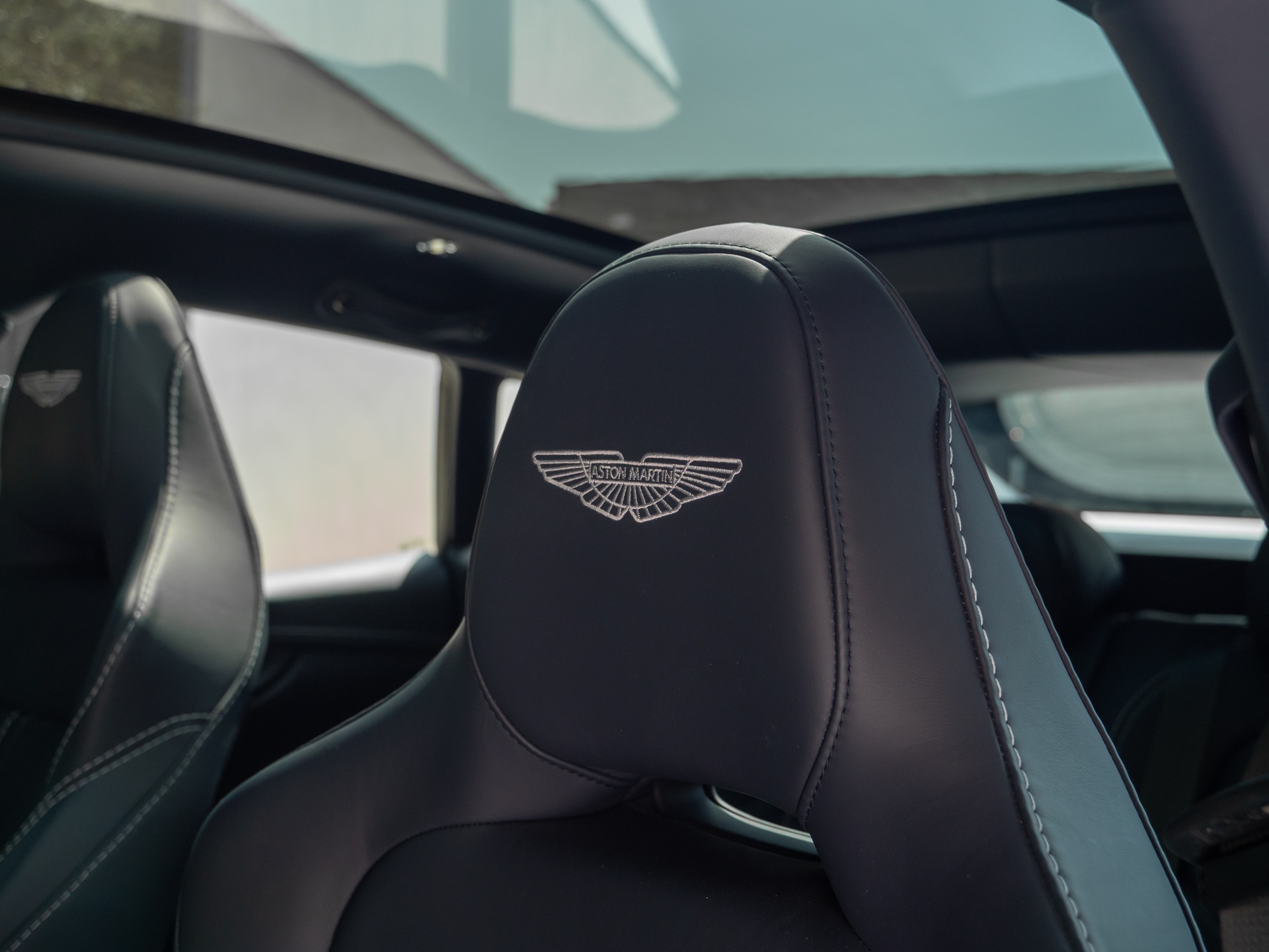Sièges en cuir avec logo – ASTON MARTIN – DBX 707 – 2024 – Titanium Grey Métallisée – 16 900 km – 707 ch – V8 bi-turbo – Transmission : Automatique – Origine France – Privaty Cars – Achat et vente de voitures de luxe d’occasion dans l’Ouest de la France
