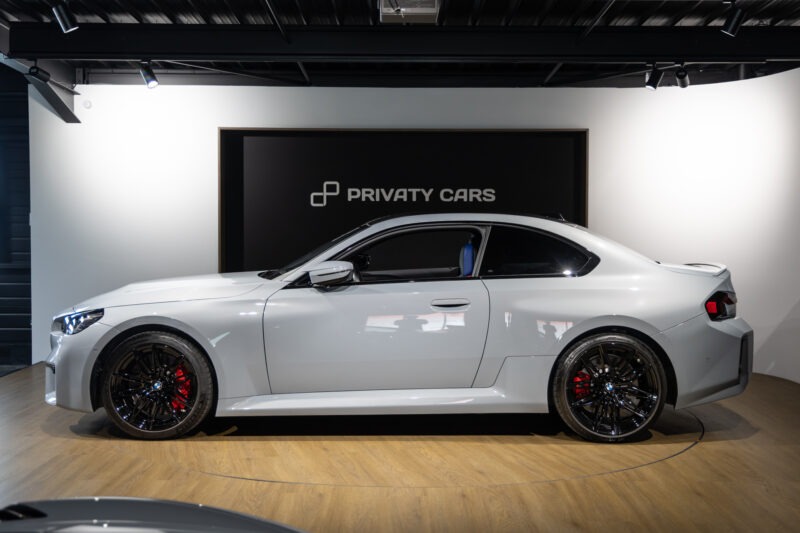 Vue latérale avec jantes noires – BMW – M2 G87 – 2023 – Brooklyngrau métalissé – 13 900 km – 460 ch – 6 en ligne bi-turbo – Transmission : Automatique – Origine France – Privaty Cars – Intermédiaire de confiance vente voiture sport dans l’Ouest de la France