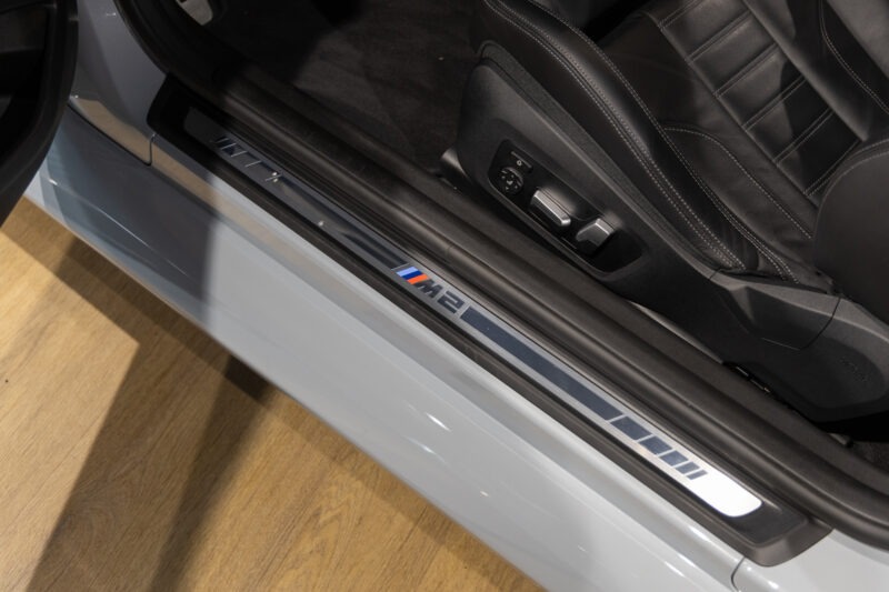 Seuil de porte avec inscription M2 – BMW – M2 G87 – 2023 – Brooklyngrau métalissé – 13 900 km – 460 ch – 6 en ligne bi-turbo – Transmission : Automatique – Origine France – Privaty Cars – Showroom de voitures de sport haut de gamme proche de Nantes