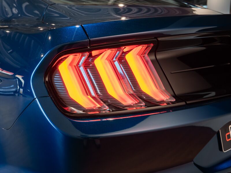 Feux arrière en forme de triple barre – PORSCHE – Ford Mustang V8 – 2019 – Bleu Kona – 48 900 km – 450 ch – V8 Atmo – Transmission : Manuelle – Origine France – Privaty Cars – Reprise cash de voitures de luxe sans obligation d’achat près de Poitiers