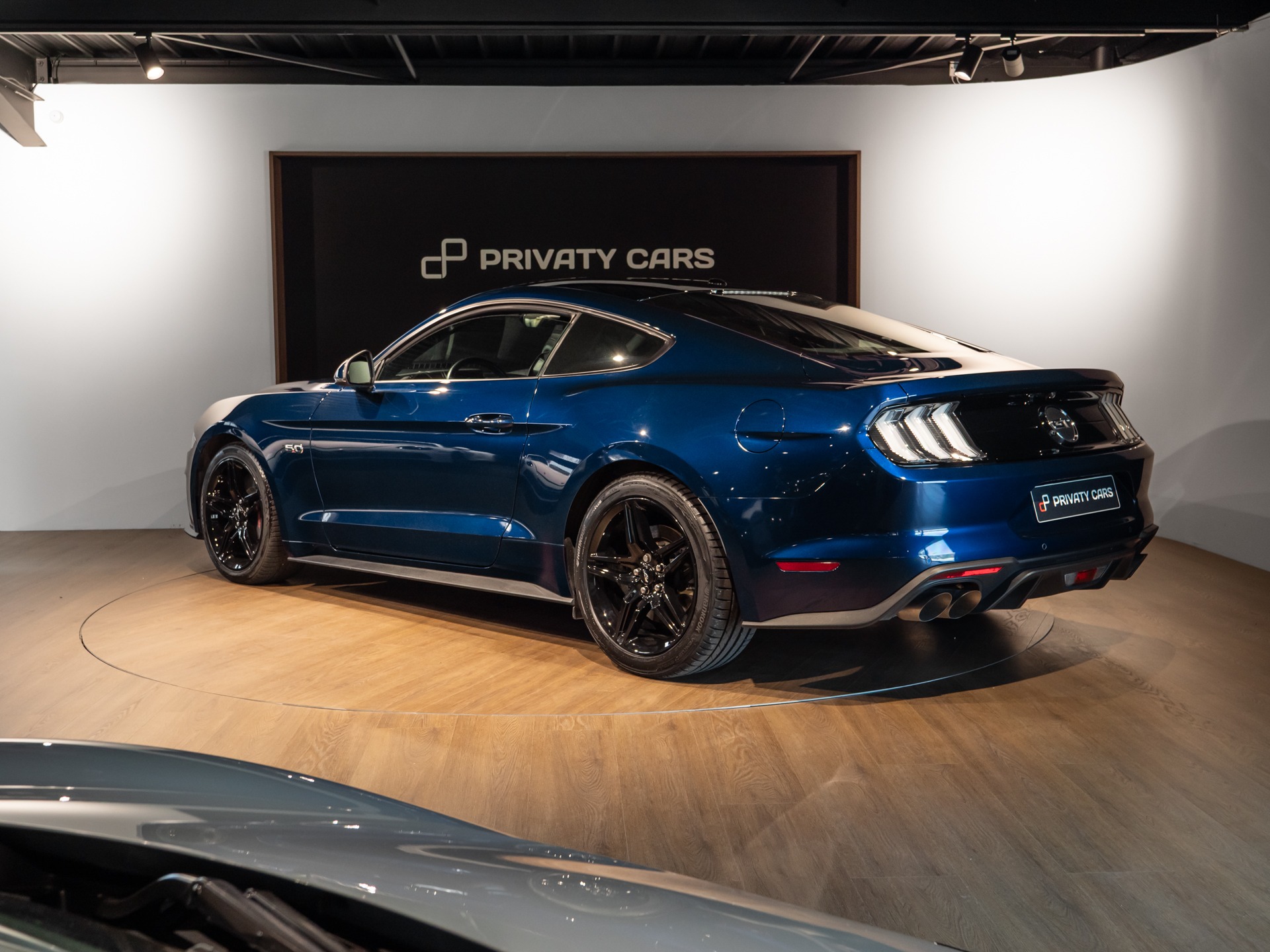 Vue arrière avec jantes noires – PORSCHE – Ford Mustang V8 – 2019 – Bleu Kona – 48 900 km – 450 ch – V8 Atmo – Transmission : Manuelle – Origine France – Privaty Cars – Importation de véhicules de prestige et sportifs proche de Nantes