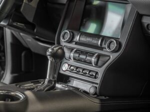 Console centrale avec levier de vitesses – FORD – Ford Mustang V8 – 2019 – Bleu Kona – 48 900 km – 450 ch – V8 Atmo – Transmission : Manuelle – Origine France – Privaty Cars – Dépôt-vente de voitures de sport et véhicules d’exception à La Rochelle