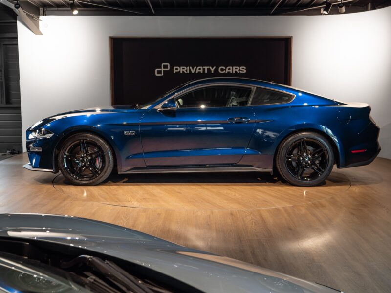 Vue latérale avec jantes noires – PORSCHE – Ford Mustang V8 – 2019 – Bleu Kona – 48 900 km – 450 ch – V8 Atmo – Transmission : Manuelle – Origine France – Privaty Cars – Recherche de supercars hors marché près de Poitiers