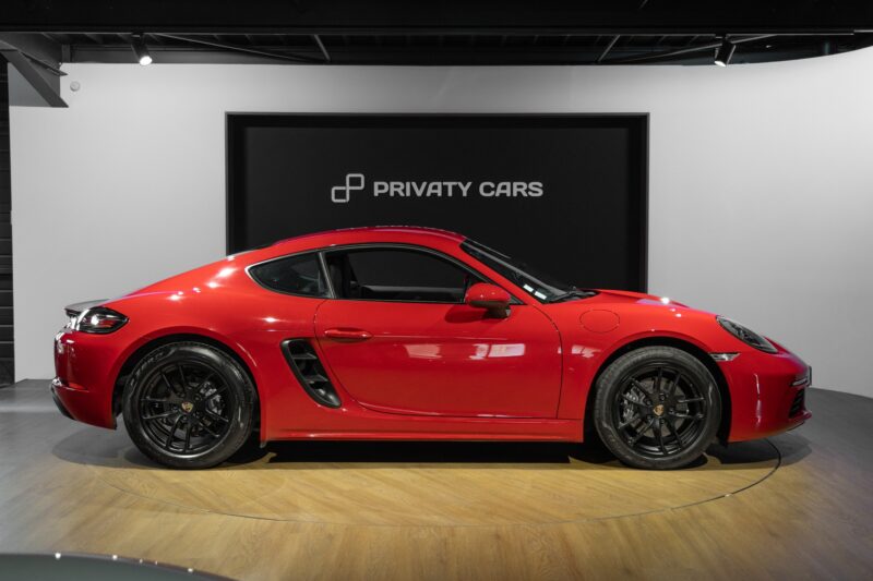 Vue latérale avec jantes noires – PORSCHE – 718 CAYMAN – 2017 – Rouge Carmin – 64 900 km – 300 ch – Flat 4 turbo – Transmission : Automatique – Origine France – Privaty Cars – Expert des sportives d’occasion haut de gamme près de Niort