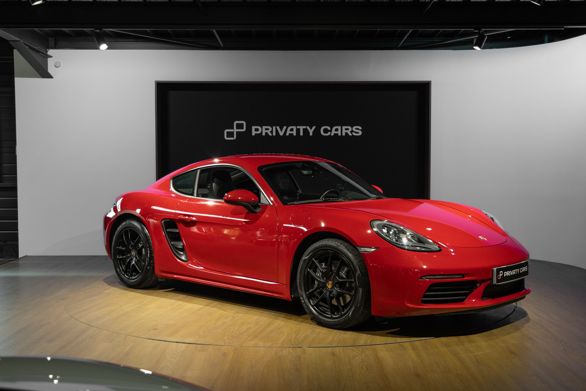 Vue latérale avec jantes noires – PORSCHE – 718 CAYMAN – 2017 – Rouge Carmin – 64 900 km – 300 ch – Flat 4 turbo – Transmission : Automatique – Origine France – Privaty Cars – Spécialiste des supercars d’occasion proche de Nantes