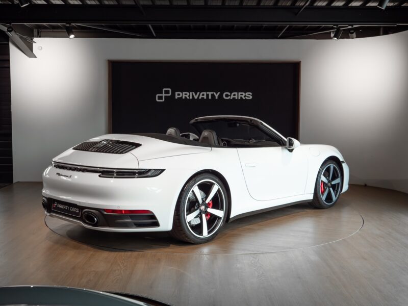 Vue arrière avec capot moteur ajouré – PORSCHE – 911 992.1 S Cabriolet – 2020 – Blanc – 16 900 km – 450 ch – Flat 6 bi-turbo – Transmission : séquentielle – Origine Allemagne – Privaty Cars – Dépôt-vente de voitures de sport et véhicules d’exception dans l’Ouest de la France