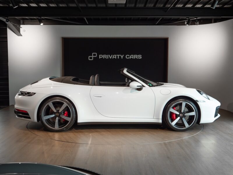 Vue latérale avec toit replié – PORSCHE – 911 992.1 S Cabriolet – 2020 – Blanc – 16 900 km – 450 ch – Flat 6 bi-turbo – Transmission : séquentielle – Origine Allemagne – Privaty Cars – Spécialiste des sportives d’occasion en Charente-Maritime