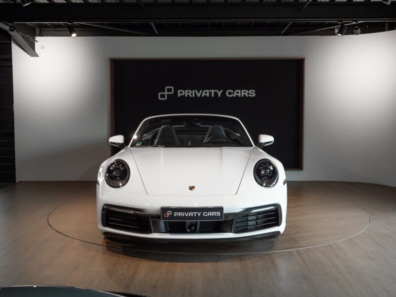 Vue avant avec phares ronds – PORSCHE – 911 992.1 S Cabriolet – 2020 – Blanc – 16 900 km – 450 ch – Flat 6 bi-turbo – Transmission : séquentielle – Origine Allemagne – Privaty Cars – Vente de voitures de sport d’occasion dans l’Ouest de la France