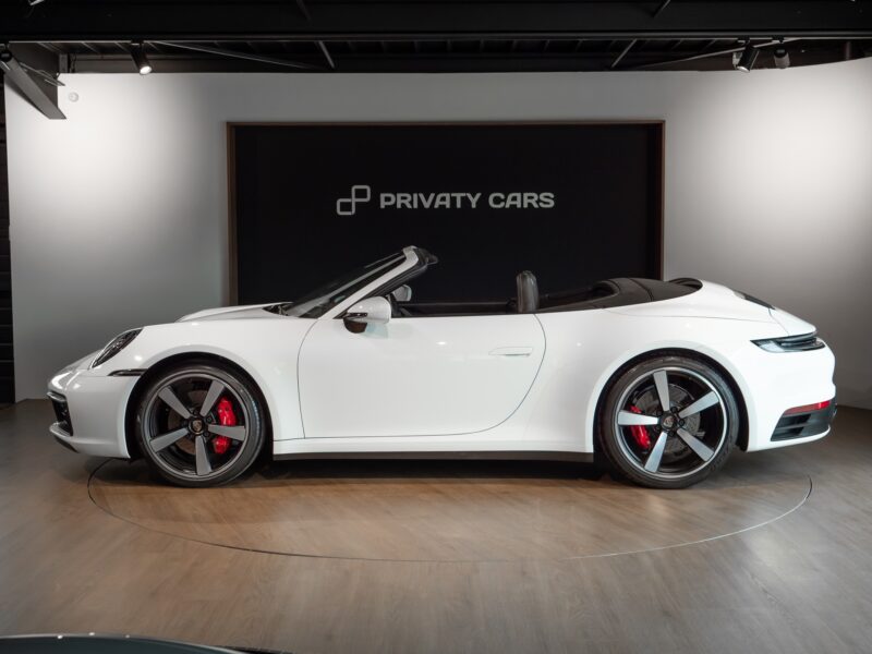 Vue latérale avec jantes sportives – PORSCHE – 911 992.1 S Cabriolet – 2020 – Blanc – 16 900 km – 450 ch – Flat 6 bi-turbo – Transmission : séquentielle – Origine Allemagne – Privaty Cars – Vente de voitures de prestige d’occasion en Charente-Maritime