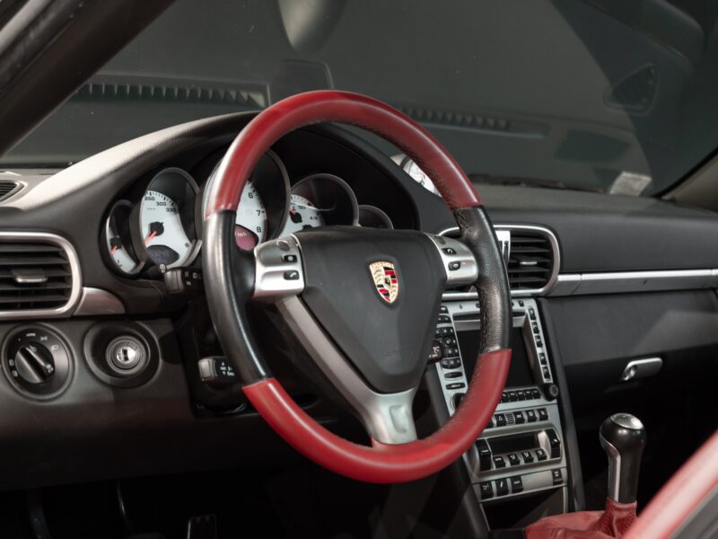 Volant avec cuir rouge et noir – PORSCHE – 911 997 4S – 2007 – Noir Basalte Métallisée – 83 900 km – 355 ch – Flat 6 Atmo – Transmission : Manuelle – Origine Danemark – Privaty Cars – Expert des modèles PORSCHE à La Rochelle