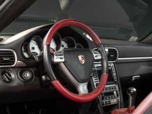 Volant avec garniture rouge et noire – PORSCHE – 911 997 4S – 2007 – Noir Basalte Métallisée – 83 900 km – 355 ch – Flat 6 Atmo – Transmission : Manuelle – Origine Danemark – Privaty Cars – Spécialiste indépendant Porsche, Ferrari et McLaren dans l’Ouest de la France