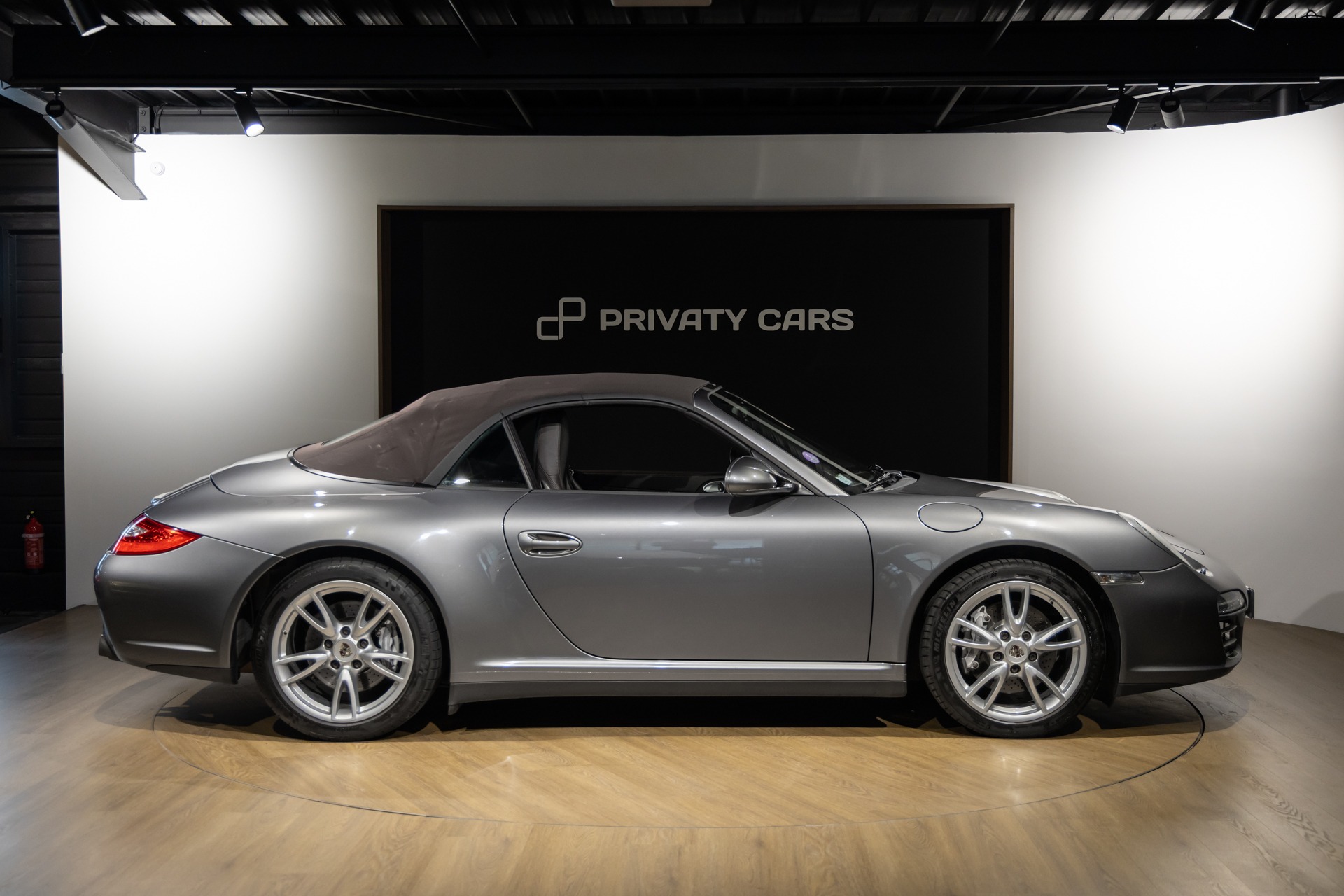 Vue latérale avec toit replié – PORSCHE – 911 997 Carrera 4 – 2011 – Gris Météore – 127 000 km – 345 ch – Flat 6 atmo – Transmission : Sequentielle – Origine Pays Bas – Privaty Cars – Vente de voitures de prestige d’occasion à 2 heures de Paris en TGV