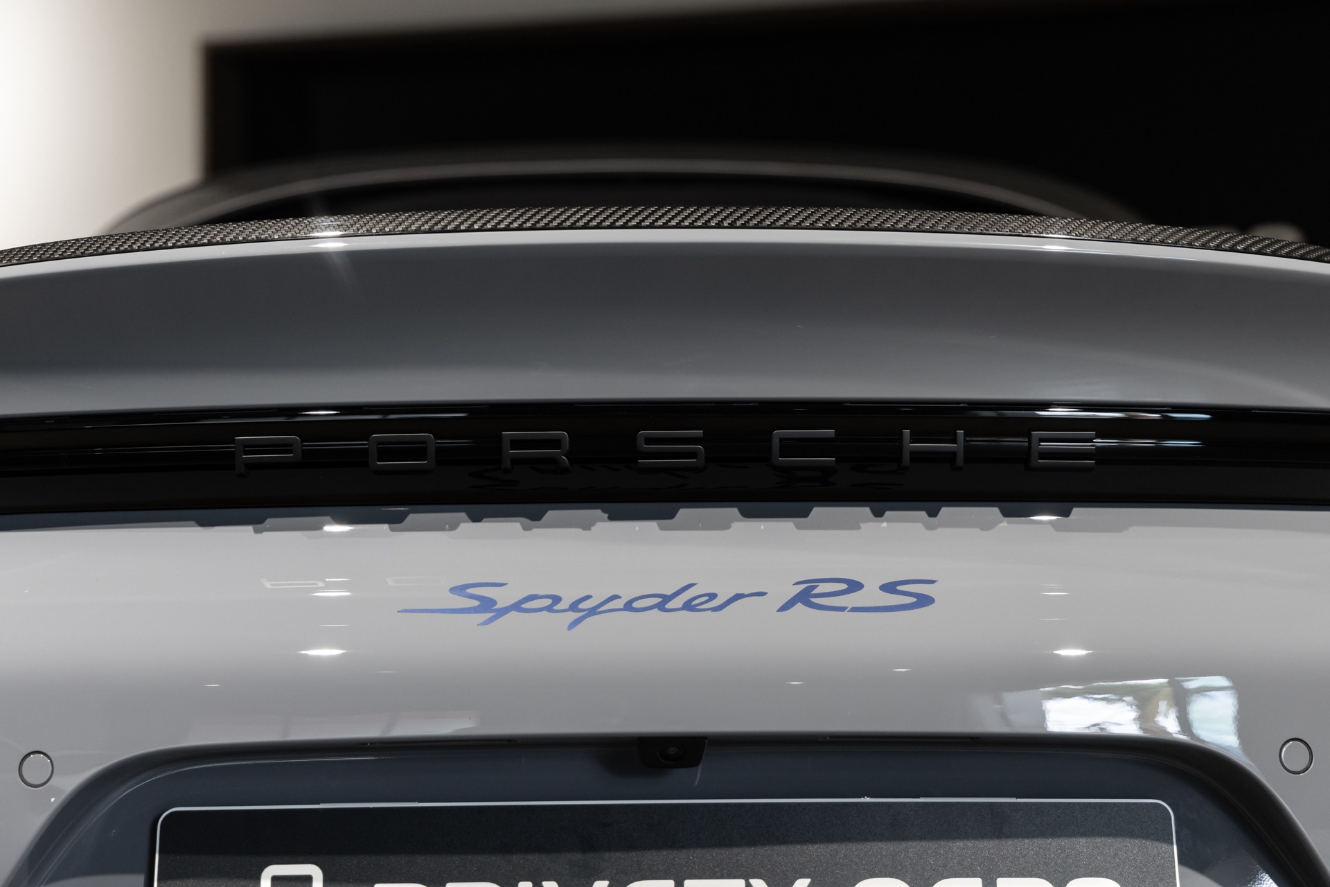 Logo arrière avec inscription – PORSCHE – 718 Spyder RS – 2025 – Gris Arctique – 4 500 km – 500 ch – Flat 6 Atmo – Transmission : Sequentielle – Origine France – Privaty Cars – Expert des modèles PORSCHE dans l’Ouest de la France