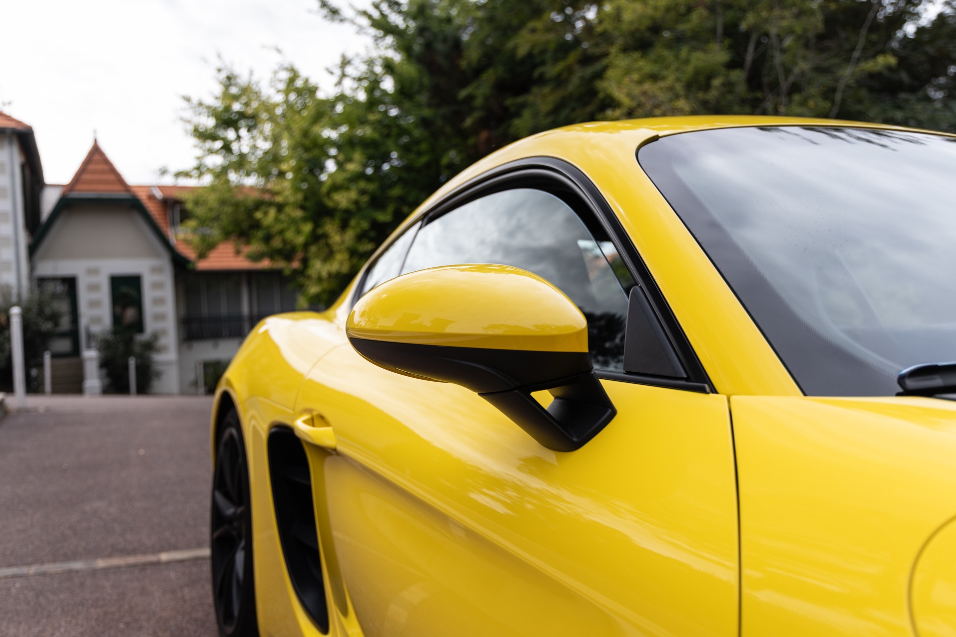 Rétroviseur extérieur avec contours noirs – PORSCHE – 718 CAYMAN – 2018 – Jaune Racing – 51 900 km – 365 ch – Flat 4 turbo – Transmission : Automatique – Origine Allemagne – Privaty Cars – Rachat express de supercars et hypercars près de Niort