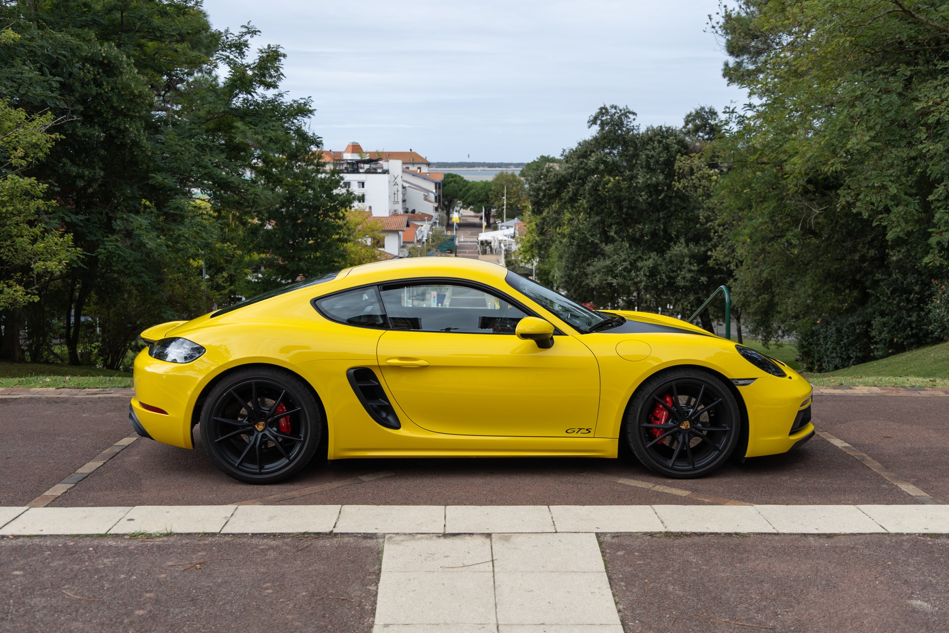 Vue latérale avec jantes noires – PORSCHE – 718 CAYMAN – 2018 – Jaune Racing – 51 900 km – 365 ch – Flat 4 turbo – Transmission : Automatique – Origine Allemagne – Privaty Cars – Courtage automobile pour véhicules exclusifs près de Poitiers