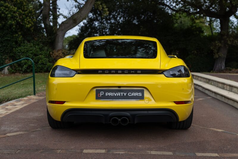 Vue arrière avec double sortie d'échappement – PORSCHE – 718 CAYMAN – 2018 – Jaune Racing – 51 900 km – 365 ch – Flat 4 turbo – Transmission : Automatique – Origine Allemagne – Privaty Cars – Chasseur de voitures de sport sur mesure à 2 heures de Paris en TGV